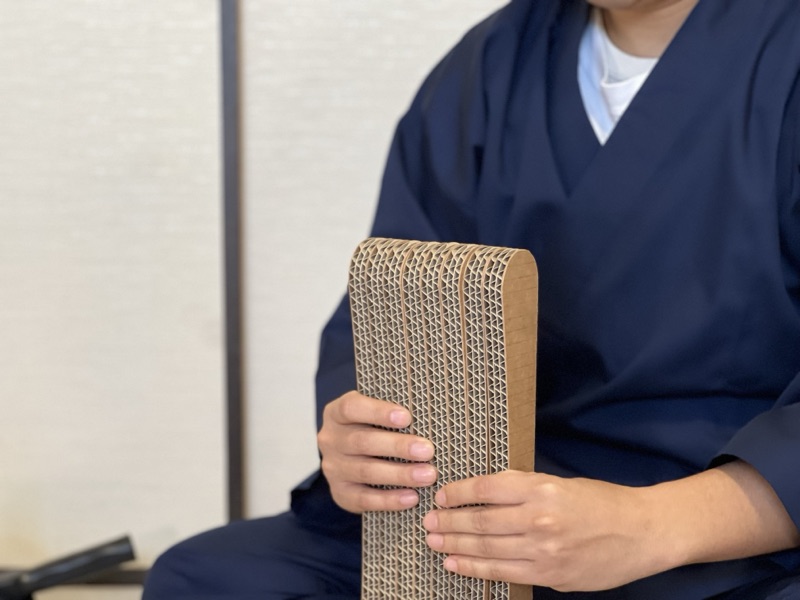 職人が手貼りで爪とぎを仕上げている様子